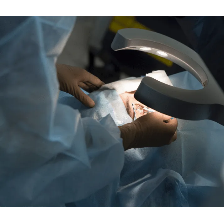 Cirurgião realizando cirurgia refrativa a laser em paciente sob equipamento cirúrgico